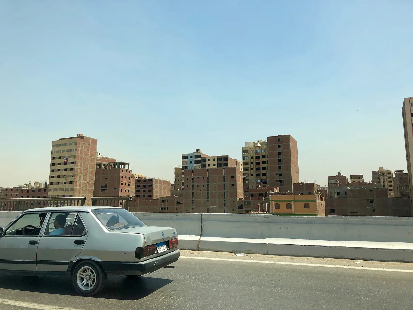 زحام مروري كثيف في أحد شوارع القاهرة، حيث تتشارك السيارات والمشاة الطريق.