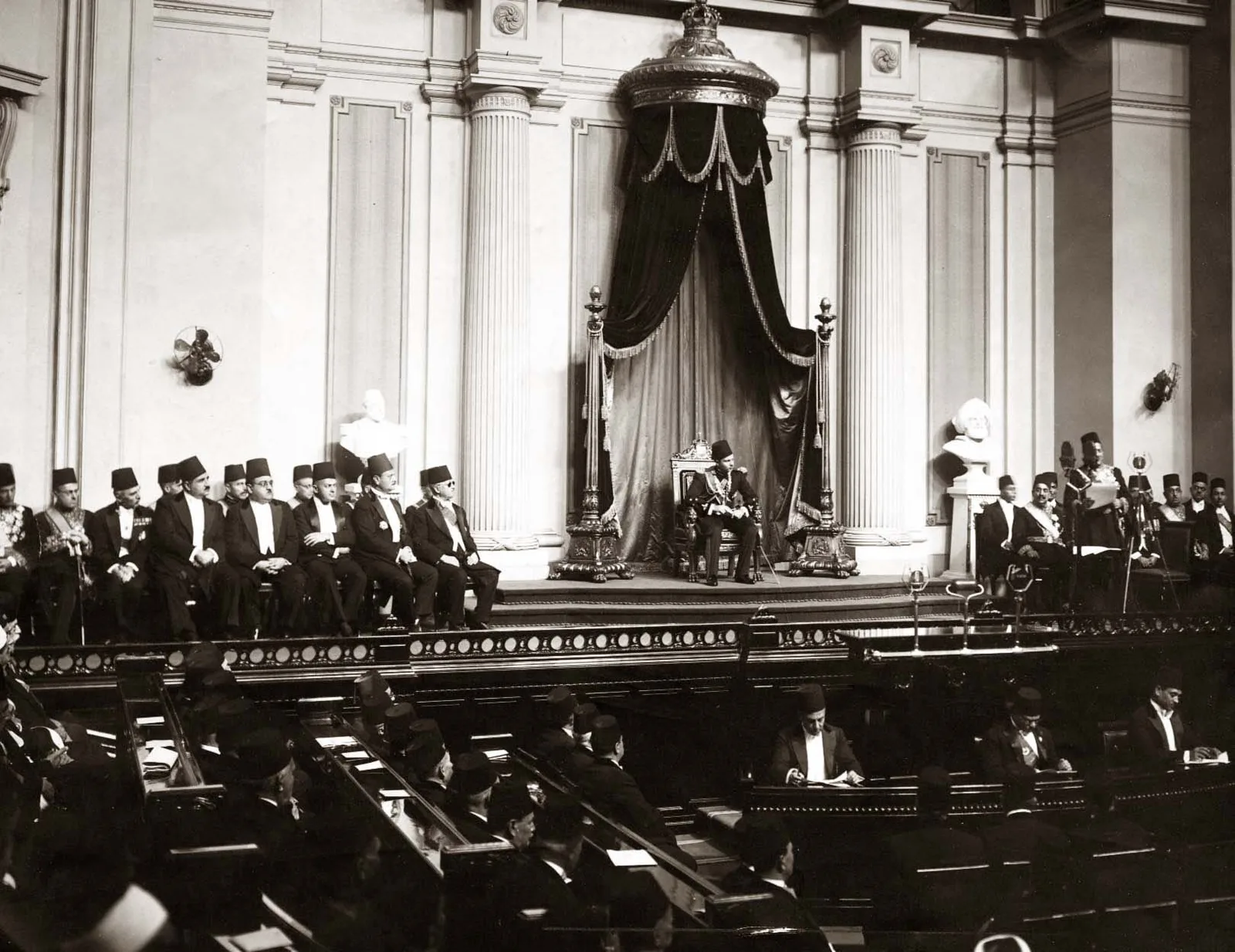قاعة البرلمان المصري في جلسة عام 1937: الأعضاء بالطرابيش في مقاعدهم الخشبية، والملك على المنصة تحت سرادق مزخرف