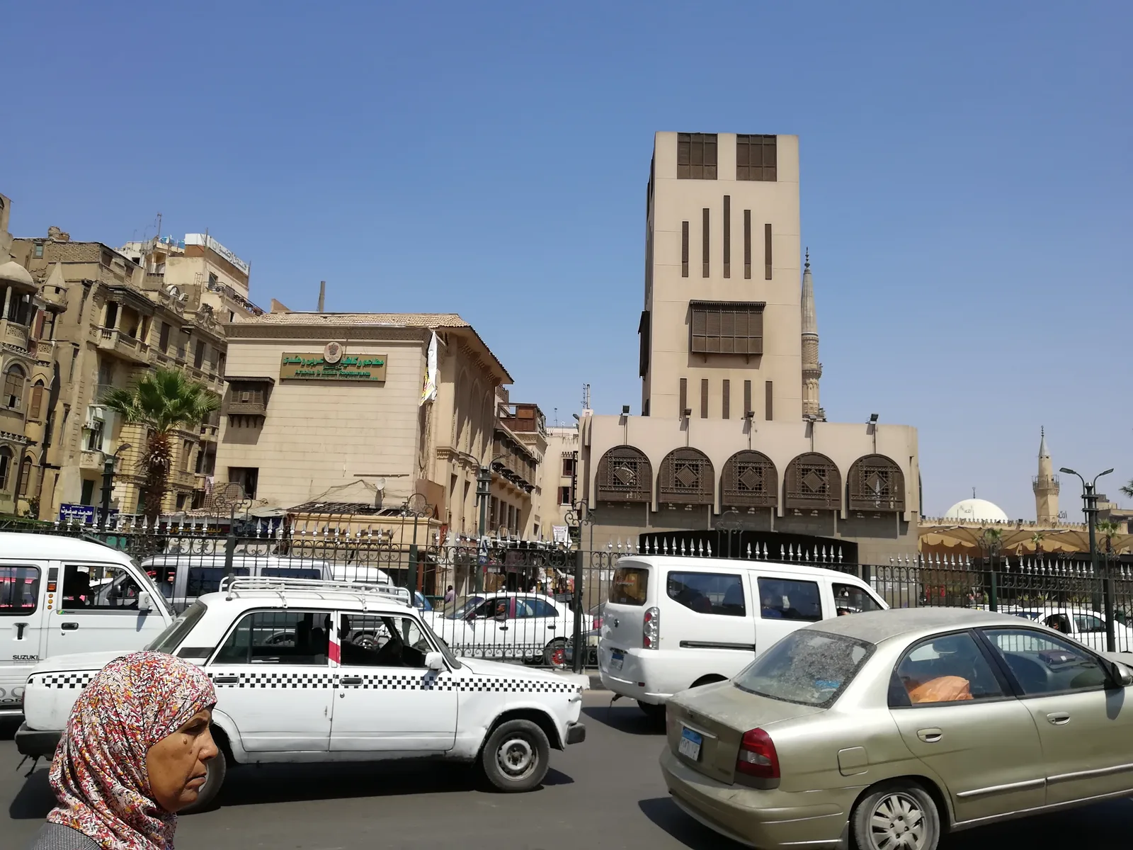 شارع الأزهر بالقاهرة تزدحم به التاكسيات والميكروباصات، وتظهر مئذنة وقبة مسجد في الخلفية
