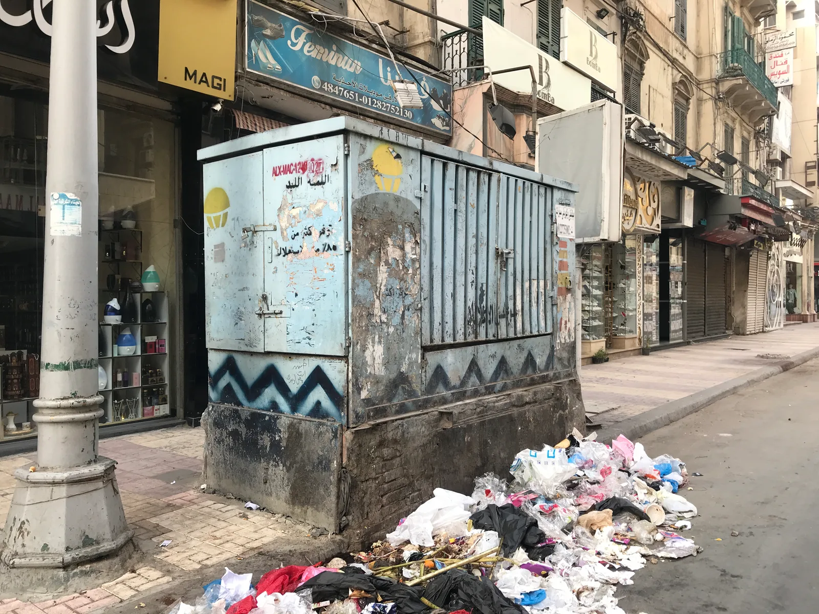 أكوام من الأكياس والمخلفات ملقاة عند كشك على رصيف شارع سعد زغلول بالإسكندرية