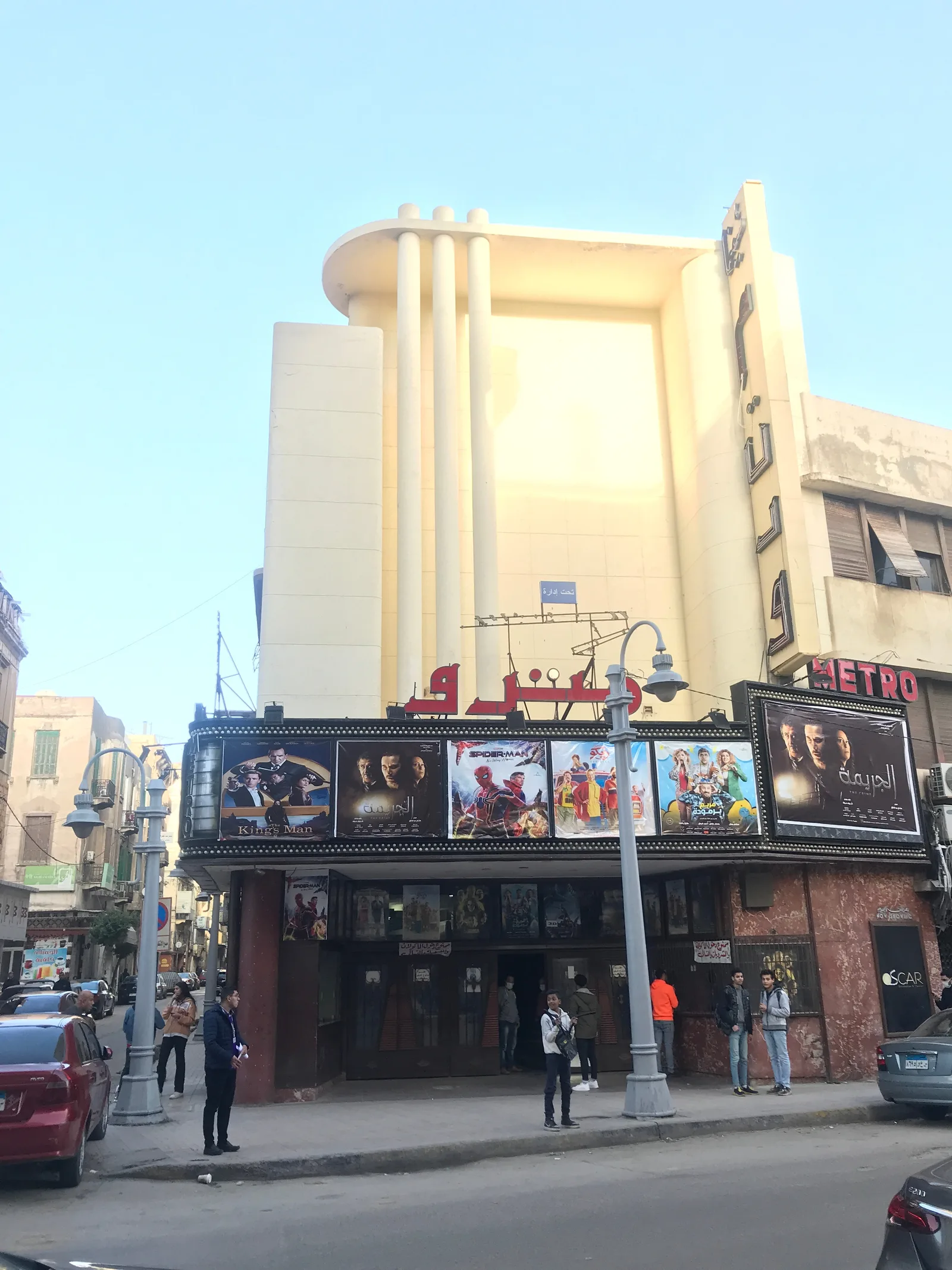 واجهة سينما مترو بالإسكندرية على طراز الآرت ديكو وأفيشات الأفلام معلقة تحتها، والمارة أمام شباك التذاكر