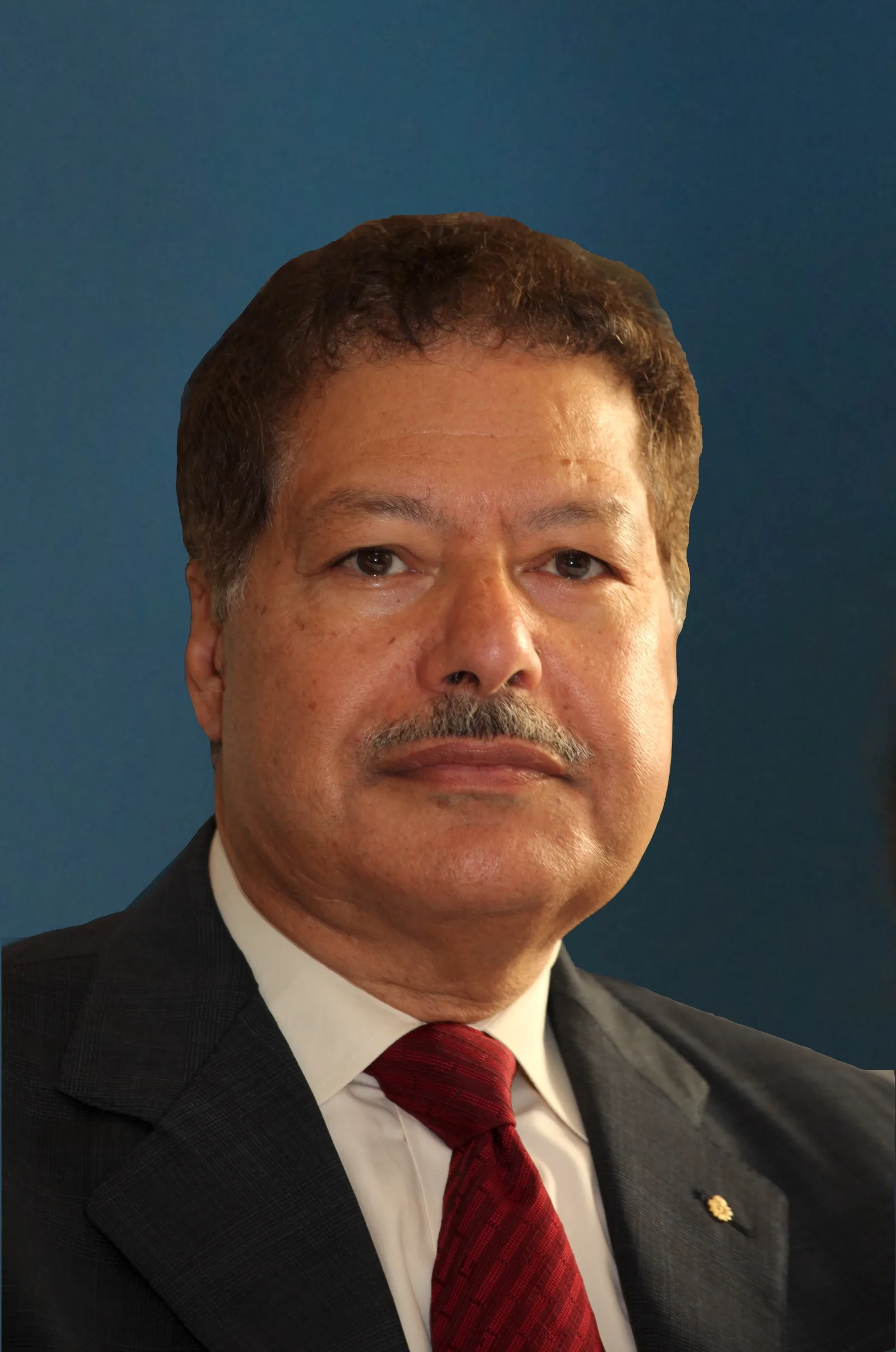 صورة شخصية للعالم المصري أحمد زويل، الحائز على جائزة نوبل في الكيمياء عام 1999، يرتدي بدلة داكنة وربطة عنق حمراء